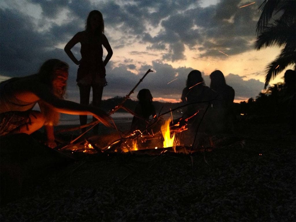 Students at a beach bonfire